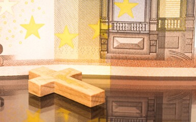 Symbolbild Kirchensteuer: Euro-Banknoten vor Kirchengebäude – Ratgeber zu Höhe, Kappung und Kirchgeld 2025