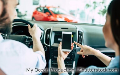 Junges Ehepaar nutzt die i-Kfz-App für Ihren digitalen Fahrzeugschein.