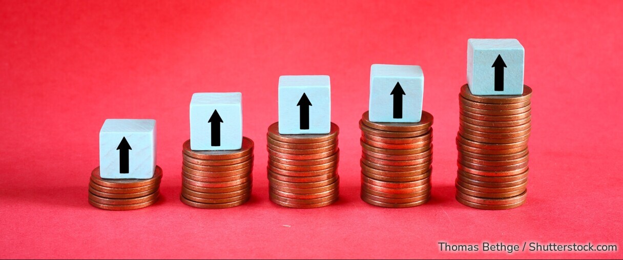 Symbolbild: Münzstapel mit Pfeilen nach oben stehen für steigende Zinsen und höhere Erträge bei Sparanlagen wie Tagesgeld.