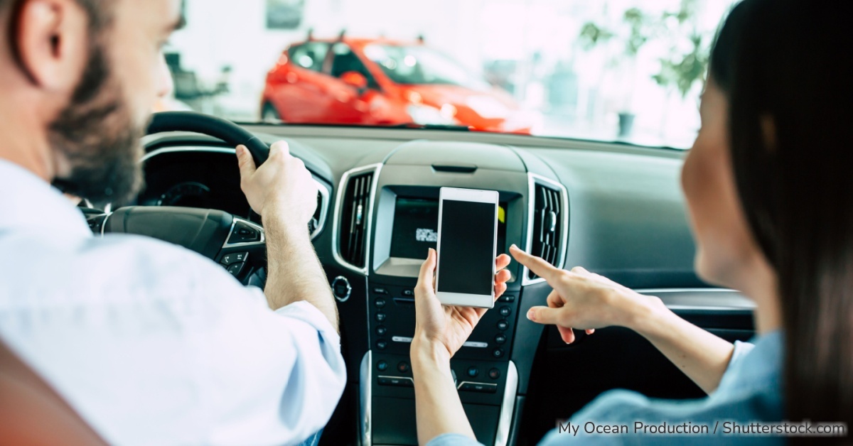 Junges Ehepaar nutzt die i-Kfz-App für Ihren digitalen Fahrzeugschein.