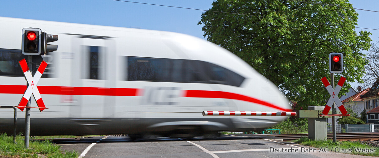 ICE fährt über Bahnübergang.
